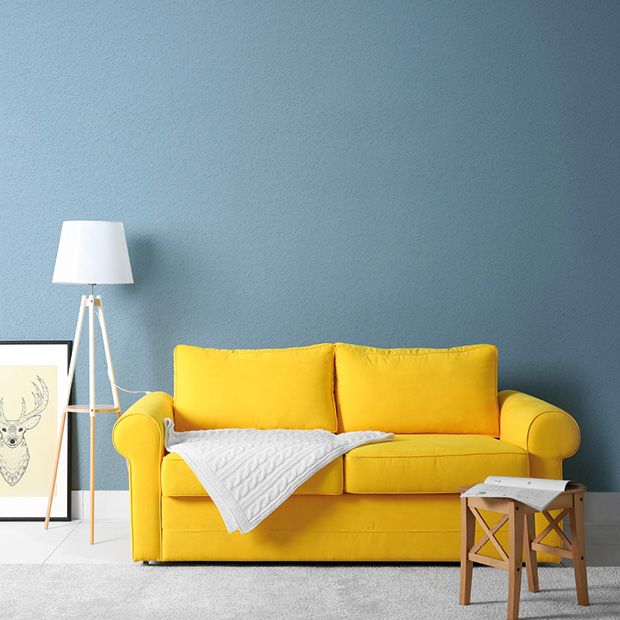 Wohnzimmer mit gelbem Sofa, blauer Wand, Tapeten von Erfurt und nachhaltiger Farbe von Mynt