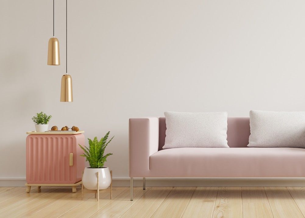Modernes Wohnzimmer mit farbigen Möbeln, Paketboden, Pflanzen und tief hängender Lampe.